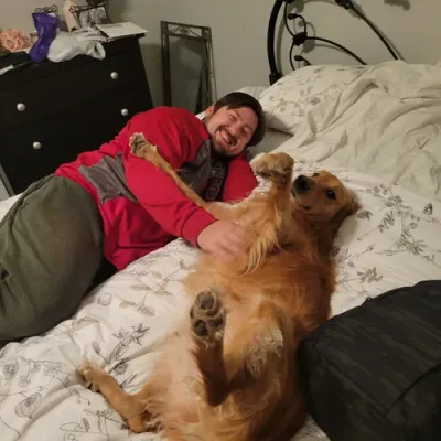 Andy relaxing with a golden retriever